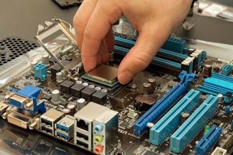 Handen monterar en processor på ett datorns moderkort