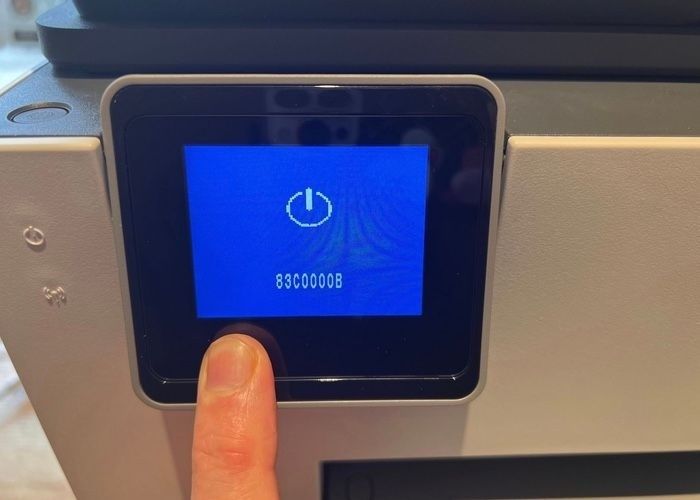 Närbild av en apparats blå skärm med felkod och påslagningssymbol